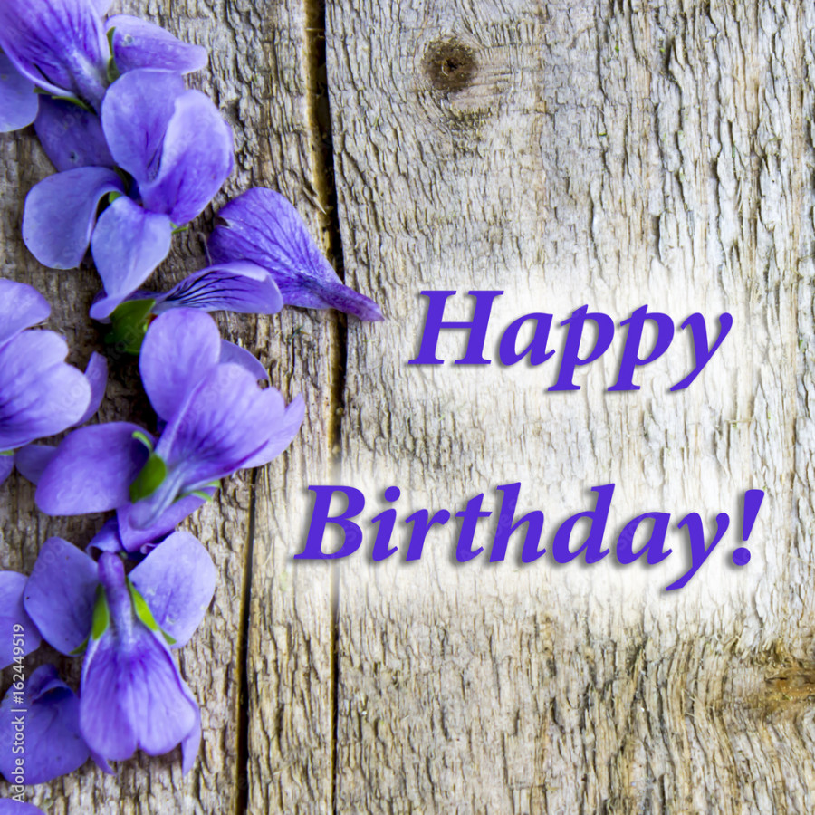 Card "Happy birthday", light wooden background, violet flowers of